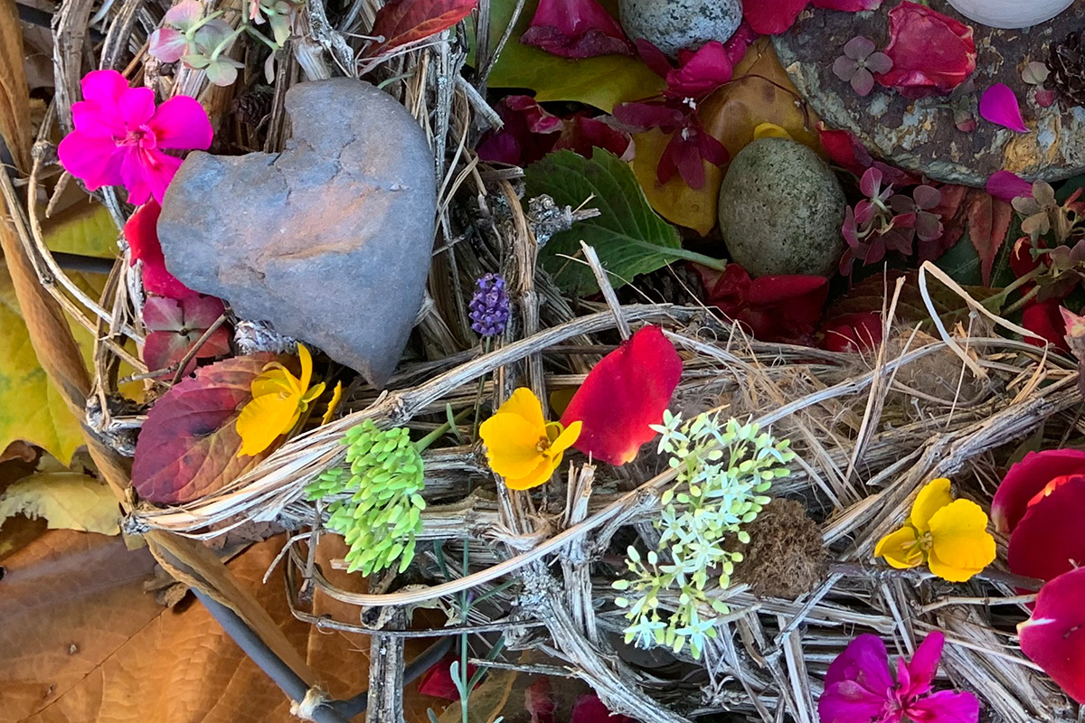 Graues Herz in einem Blumenkranz